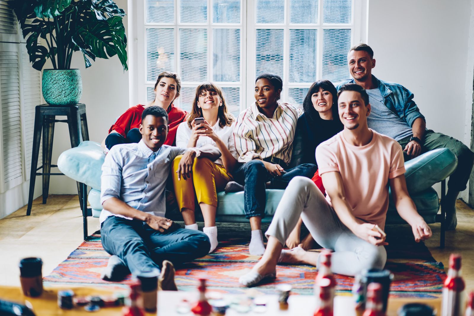shutterstock_1708645786 friends sitting in room watching TV smiling